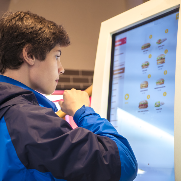 Man ordering fast food on digital signage screen